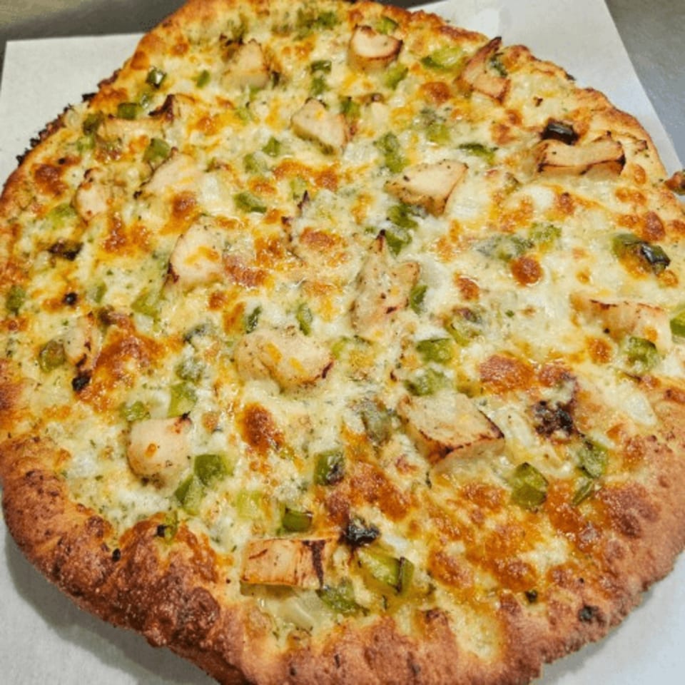 A whole Pizza Roma chicken and green pepper pizza with melted cheese and a golden crust.
